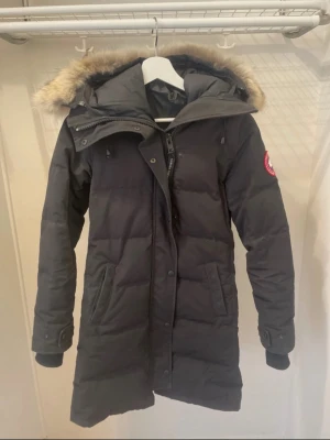 Svart lång dunjacka Canada Goose - Säljer nu min älskade Goose!   Den är i väldigt bra skick, fin i pälsen och varm och skön nu på vintern!   Nypris: 13000kr