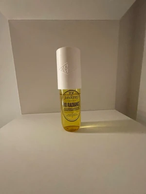 Sol de Janeiro Rio Radiance parfym - Fräsch parfymmist från Sol de Janeiro i doften Rio Radiance. Flaskan är genomskinlig med gul vätska och har ett stort vitt lock med präglad logga. Perfekt för dig som gillar tropiska och soliga dofter.