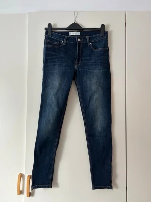 Mörkblå skinny jeans från Mango - Snygga mörkblå skinny jeans med klassisk femficksmodell och dragkedja vid benslut. Jeansen har en lätt tvättad look och kontrastsömmar som ger en trendig vibe. Perfekta till sneakers eller boots.