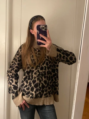 Leopardmönstrad stickad tröja - Säljer en stickad tröja med leopardmönster i beige/ ljusbrunt och svart. 