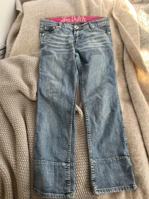 Blå bootcut jeans från Von Dutch - Säljer ett par blå bootcut jeans från Von Dutch med låg midja och coola detaljer. 