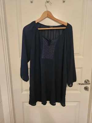 Mörkblå tunn tunika i storlek 48 - En mörkblå tunn tunika med trekvartsärm i storlek 48 från Esmara Fashion i nyskick. Bröstmått 110 cm, längd 75 cm.