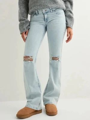 Ljusblå bootcut jeans med slitningar - Säljer ett par ljusblå bootcut jeans med slitna knän och broderade detaljer på bakfickorna. Jeansen har  låg midja. Storlek 36.