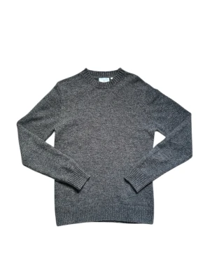 Stickad tröja från bläck - Klassisk mörkgrå stickad tröja med rund hals och ribbade muddar vid ärmslut och nederkant. Tröjan är tillverkad i mjuk ullmix och har en enkel, stilren design som passar perfekt till lager på lager under kalla dagar.