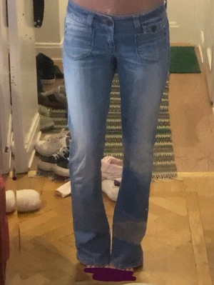 Ljusblå bootcut jeans från Levi's - Säljer ett par ljusblå bootcut, Jeansen har låg midja och utsvängda ben, samt snygga kontrastsömmar och Levi's-röd etikett bak. Perfekta för en avslappnad och trendig look. Innerbenslängd 80cm