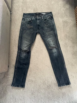 Mörkblåa replay jeans - Hej! Säljer ett par mörkblåa slim fit jeans från Replay, modell Anbass.Jeansen har slitningar på byxorna, vid mer frågor eller funderingar är det bara att höra av sig! Mvh