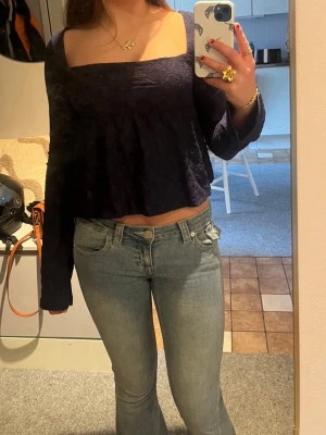 Mörkblå croppad topp med lång ärm från Nelly - Trendig mörkblå croppad topp med fyrkantig ringning och långa ärmar. I storlek xs. Säljs eftersom jag inte använder.