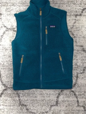 fleeceväst från Patagonia - Sällsynt mörk blå/grön (teal) Patagonia fleeceväst i storlek S  Mjuk, varm och perfekt som lager-på-lager. Väldigt fin färg som är svår att hitta. Aldrig använd (byte mot mörkblå patagonia väst går också)