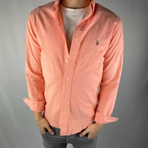 Ralph Lauren  - Riktigt snygg Ralph Lauren skjorta i storlek S. Den är i riktigt bra sick inga antydningar på andväning. Färgen är aprikos. Skjortan passar riktigt bra inför vår och sommar.