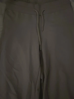 Beige mjukisbyxor med snörning - Säljer ett par beige mjukisbyxor med snörning i midjan. De har en relaxed passform och är perfekta för chill dagar. Tillverkade i mjukt material som känns skönt mot huden.