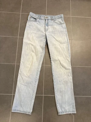 Ljusblå raka jeans från Flash, Stl 32 - Säljer ett par ljusblå jeans med rak passform och klassisk femficksdesign. Jeansen har bälteshällor, knappgylf och är tillverkade i denim. Perfekta för en avslappnad och trendig look.