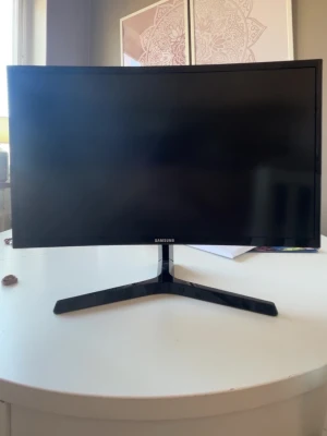 Svart böjd datorskärm från Samsung - Snygg svart böjd datorskärm från Samsung med stilren design och stabilt stativ. Skärmen har tunn ram och passar perfekt för gaming eller arbete. Modern look och enkel att placera på skrivbordet.