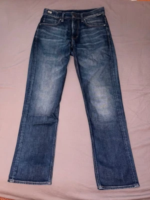 G-star Jeans W28/L30 - Mörkblå Jeans från G-star i storlek W28/L30. I otroligt fint och nytt skick, användes en enda gång och bara legat i garderoben därefter.  Ord.pris butik 1499kr, kvittot finns.  Modell: Mosa Straight Jeans - Darkblue.