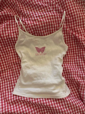 Vit linnetopp från Levi's med fjäril - Supersöt vintage Levi's linnetopp!💗linnet har inga som helst defekter och är i mycket bra skick!