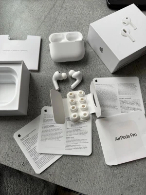 Airpods pro 3 - Säljer ett par vita Apple AirPods Pro med laddningsetui och extra silikonpluggar. Hörlurarna har en stilren och kompakt design, levereras med originalförpackning och manualer. Perfekta för dig som vill ha grymt ljud och brusreducering i ett smidigt format.