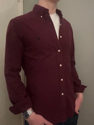 Vinröd Ralph Lauren skjorta - M slim fit - Säljer denna stilrena och snygga vinröda  Ralph Lauren skjorta. Skjortan är i mycket bra skick. Modellen är M slim fit. Har du några frågor? Tveka inte att höra av dig. Allt gott från Deluxe garderoben ⭐️