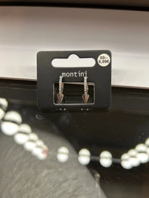 Silver örhängen  - silvriga örhängen från Montini med strass längs bågen och spetsig konformad detalj längst ner. Helt nya aldrig använda