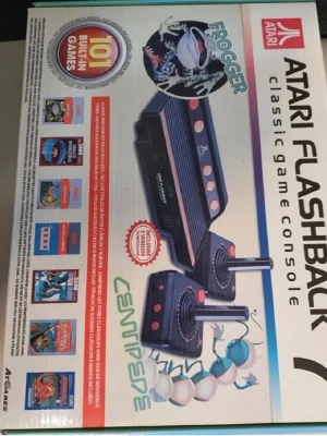 Retro spelkonsol - Retro spelkonsol från Atari, modell Flashback 7, med svart plastchassi och orange knappar. Konsolen har två klassiska joystickkontroller och AV-kablar. Innehåller 101 inbyggda spel, bland annat Frogger och Centipede. Perfekt för dig som gillar retrospel och nostalgi. Se bild för exakt beskrivning 