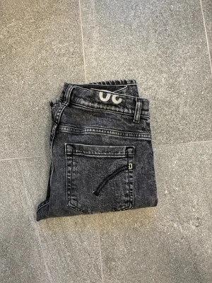 Dondup George  - Snygga svarta jeans från dondup i modellen George med tvättad look. Klassisk femficksmodell med smala ben. Jeansen har coola detaljer på bakfickorna och är tillverkade i stretchig denim för en perfekt passform.