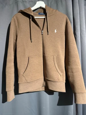 Brun hoodie från Polo Ralph Lauren - Raffe zip i toppskick. Lätt använd då den är för liten