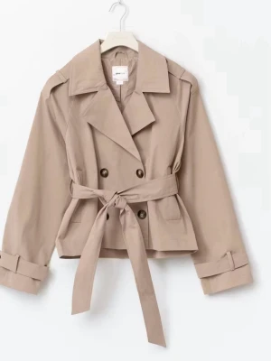 Trendig trenchcoat med knytning - Stilren kort trenchcoat i beige med dubbelknäppning, bred krage och knytskärp i midjan. Jackan har långa ärmar med dekorativa slejfar vid ärmsluten och två framfickor. Perfekt för en trendig och avslappnad look. Endast använd få gånger.