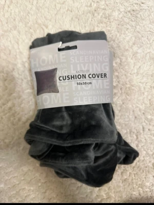 Mörkgrå sammetskuddeöverdrag 50x50 - Säljer ett mörkgrått kuddfodral i mjuk sammet, storlek 50x50 cm. Perfekt för att ge soffan eller sängen en stilren och mysig känsla. Enkel att matcha med andra färger och material.