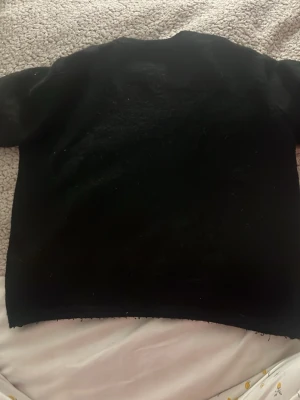 Svart stickad tröja Gina Tricot - En enkel och stilren svart stickad tröja från Gina Tricot. Tröjan har rund halsringning och korta ärmar. Perfekt basplagg att matcha med olika outfits. Mjuk och skön stickning som passar till många tillfällen.