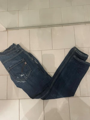Mörkblå Dondup Jeans 33/33 - Tjena! Säljer dessa dondup jeans i storlek 33/33 då dom är lite för små för mig (186cm). De har några schyssta slitningar och hål som passar de. Skriv till mig om du har några funderingar!