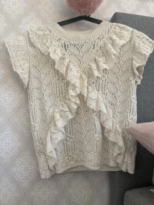 Vit Zara topp - Supersöt vit stickad topp med korta ärmar och dekorativa volanger i spets. Säljer då den inte kommer till användning