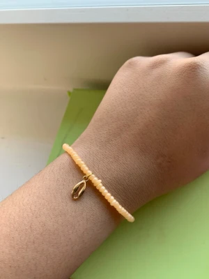 Guldring med pärldetalj - En stilren guldring med en liten vit pärla som detalj. Ringen har en tunn, elegant form och passar perfekt för dig som gillar minimalistiska smycken med en twist. Märke och material utöver guld och pärla är ej angivet.