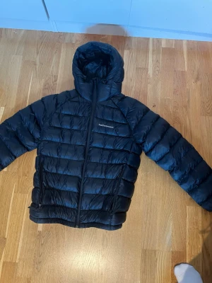 Svart dunjacka Peak Performance - Säljer denna jackan från Peak Performance. Storlek M. Normal passform. Använd 2 vintrar, men är i bra skick. Skulle kunna fluffas till lite mer i armarna bara.  Orginalpris: 3199kr