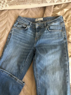 Blå raka jeans från Zara - Snygga blå jeans från Zara med klassisk femficksmodell och raka ben. Jeansen har normalhög midja och är tillverkade i mjuk denim med lätt tvättad look. Perfekta för en avslappnad och trendig stil.