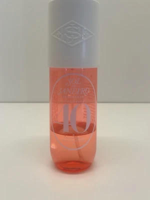 Sol de Janeiro 40 rosa parfym mist - Fräsch parfym mist från Sol de Janeiro i en snygg rosa plastflaska med vit spraykork och lock. Flaskan har en modern, cylinderformad design och tydlig logga framtill. Perfekt för dig som gillar tropiska och somriga dofter.