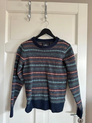 Mönstrad stickad tröja i blått och rött - Stickad tröja från L.O.G.G h&m med klassiskt mönster i blått, rött och vitt. Tröjan har rund hals, långa ärmar och ribbstickade muddar vid ärmslut och nederkant. Köpt second hand. Storlek xs💕