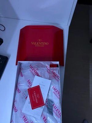 Valentino Garavani open - Snygga vita skor från Valentino Garavani med en bred svart detalj över sidan. Skorna har en klassisk låg profil och är tillverkade i läder med en chunky sula och diskreta sömmar. Perfekt för dig som vill ha en exklusiv och stilren look.