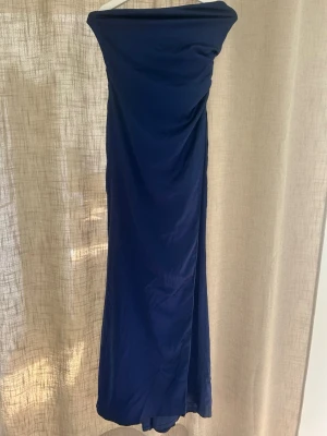 Marinblå axelbandslös långklänning - Jättefin marinblå balklänning, med en slits vid benet, använd en gång.🥰