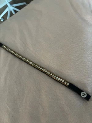 Pannband med guld och silver diamanter! 💎  - Jag säljer ett pannband med svart läder i strl cob. Jag köpte det begagnat och har bara använt ca 3 ggr av mig. Några diamanter borta men annars i fint skick!