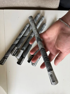 Golf Pride 7-pack - Säljer flera gråsvarta golfgrepp från Golf Pride med snyggt mönster och textur för extra grepp. Perfekt för dig som vill uppgradera dina golfklubbor med stilrena och funktionella grepp. Materialet är slitstarkt gummi och designen är modern.