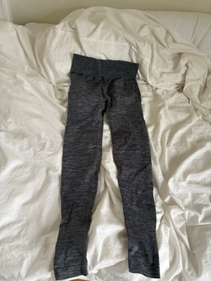 Mörkgrå sömlösa leggings - Gråa träningsbyxor i skönt material och bra kvalitet. Dom är oanvända och jag säljer pågrund av att det var fel storlek för mig. 