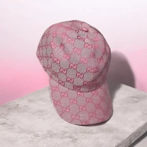 Rosa keps med mönster - Säljer en snygg rosa keps med det klassiska monogrammet i hela tyget. Kepsen har böjd skärm och justerbar baksida. Perfekt accessoar för att lyfta din streetwear-look.