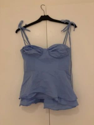 Ljusblå linnetopp med knytband - Supersöt ljusblå linnetopp med tunna axelband som knyts på axlarna. 