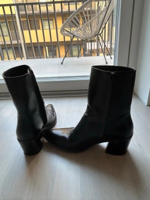 Svarta boots med klack och dragkedja - Snygga svarta stövletter i slätt skinn med medelhög blockklack och dragkedja på sidan. Klassisk siluett med något spetsig tå och stilren design som passar till många outfits. Från hm ! 