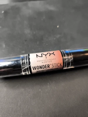 NYX Wonder Stick i färgen WS03 Deep 🤎 - NYX Wonder Stick är en dubbeländad contour- och highlightstick i färgen Deep. Stiftet har en krämig formula och kommer i svart plast med tydlig märkning. Perfekt för att skapa markerade kindben och highlighta ansiktet med enkel applicering.