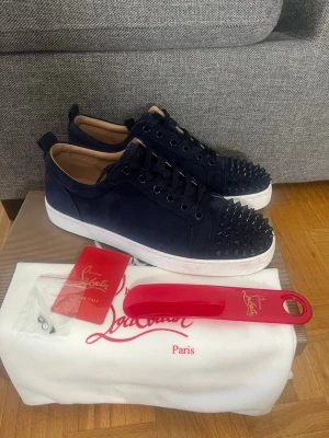 Marinblå Christian Louboutin skor - Säljer mina Christian Louboutins skor som jag använt i ett sparsamt skick😇 Allt på bild följs med och jag tvättar skorna innan frakt. Hör av er vid funderingar samt snabbaffär