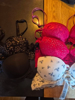 Färgglada bhar i spets och bomull - Säljer flera bhar i olika färger och stilar: svarta med spets och blommönster, vita med blå blommor i ribbad bomull samt rosa spetsbhar med strass och rosetter. Perfekta för dig som vill ha variation i underklädeslådan.    Samtliga i storlek 75A från New Yorker.      Alla kläder rollas innan dom skickas hem då det finns katt i hemmet🐈 Jag stryker och tvättar INTE innan jag skickar det får du stå för själv så det blir som du vill ha det🤗
