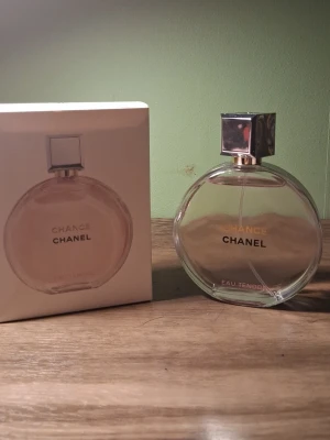 Chanel Chance Eau Tendre parfym 100ml - Chanel Chance Eau Tendre är en lyxig parfym i en rund, transparent glasflaska med silverfärgad fyrkantig kork. Flaskan rymmer 100 ml och har eleganta guld- och svartfärgade detaljer på etiketten. Perfekt för dig som vill ha en fräsch och exklusiv doft.