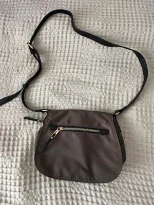 Axelremsväska - En axelremsväska i nylon, färgen är militärgrön. Storlek 18x24. Aldrig använts. 🌸