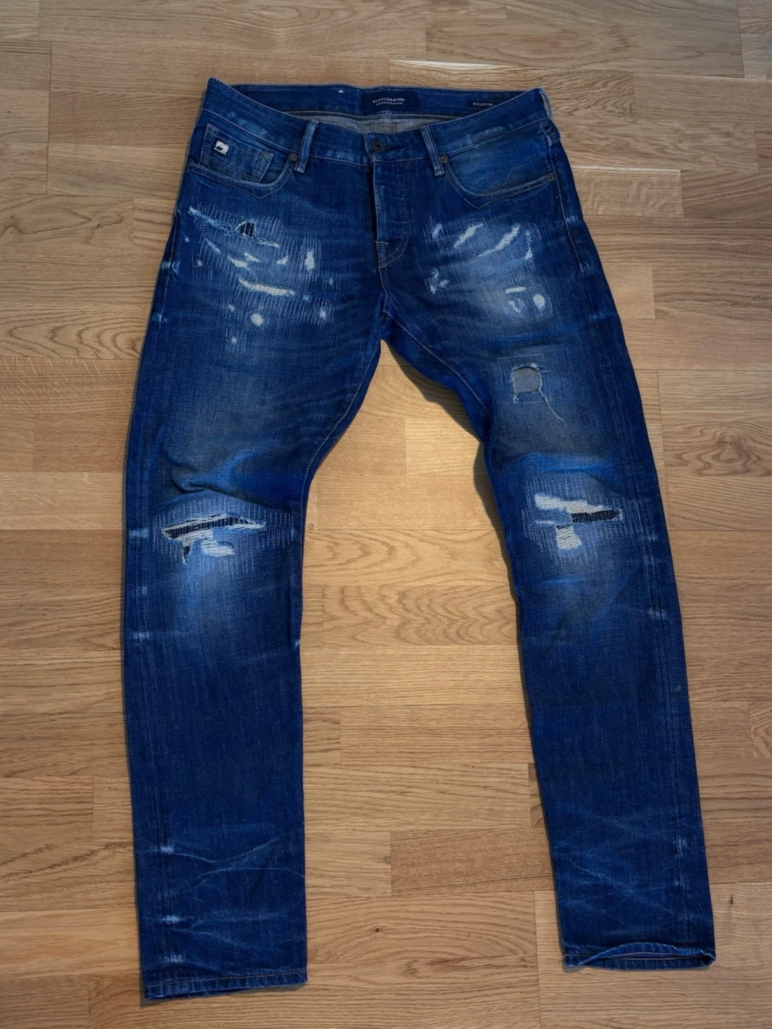 Blåa jeans distressed med randig bakficka