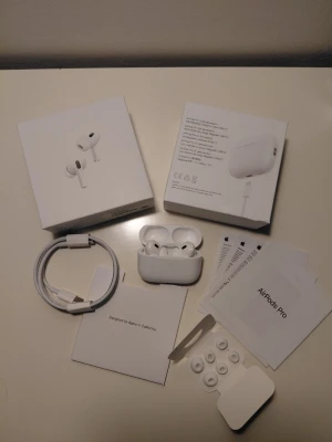 Apple AirPods Pro med laddningsetui - Säljer ett par vita Apple AirPods Pro med trådlöst laddningsetui. Hörlurarna har silikonproppar och levereras med extra öronproppar i olika storlekar. Snygg och stilren design i blank plast, perfekt för dig som vill ha grymt ljud och smidig anslutning till din iPhone. #apple #airpods #iPhones #airpodspro2