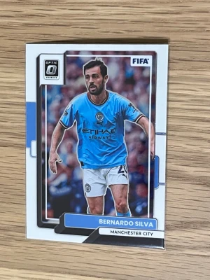 Fotbollskort Bernardo Silva Man City - Säljer ett samlarkort från Panini Donruss Soccer med Bernardo Silva Optic  i Manchester Citys ljusblå matchtröja. Kortet har tydliga klubb- och spelardetaljer samt text på baksidan om spelaren. Perfekt för dig som gillar fotboll och samlar på sportkort.